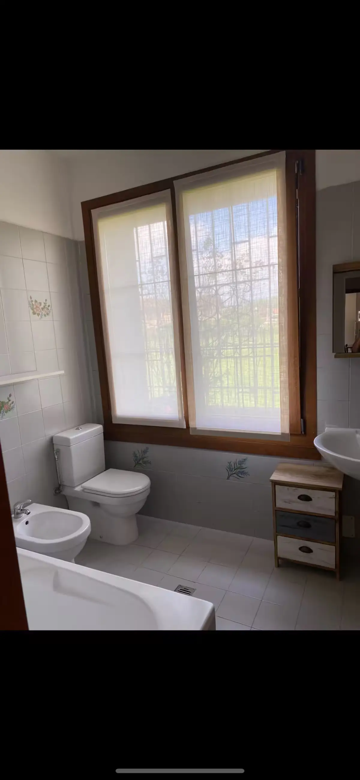 Apartment bathroom wide angle with bathtub and window