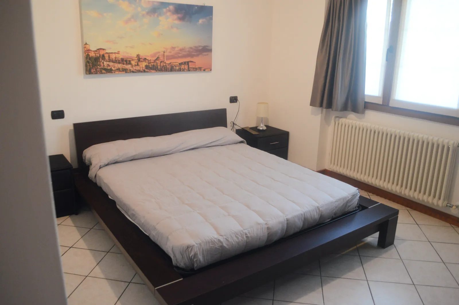 Bedroom with cityscape canvas above the bed
