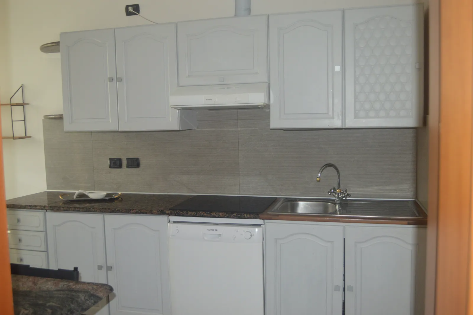 Full apartment kitchen with white cabinets and granite counter