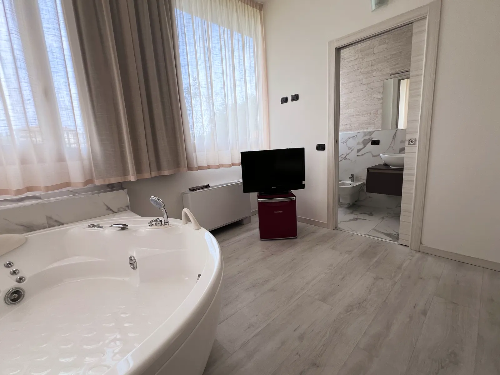 Suite with Jacuzzi, TV, and en-suite bathroom
