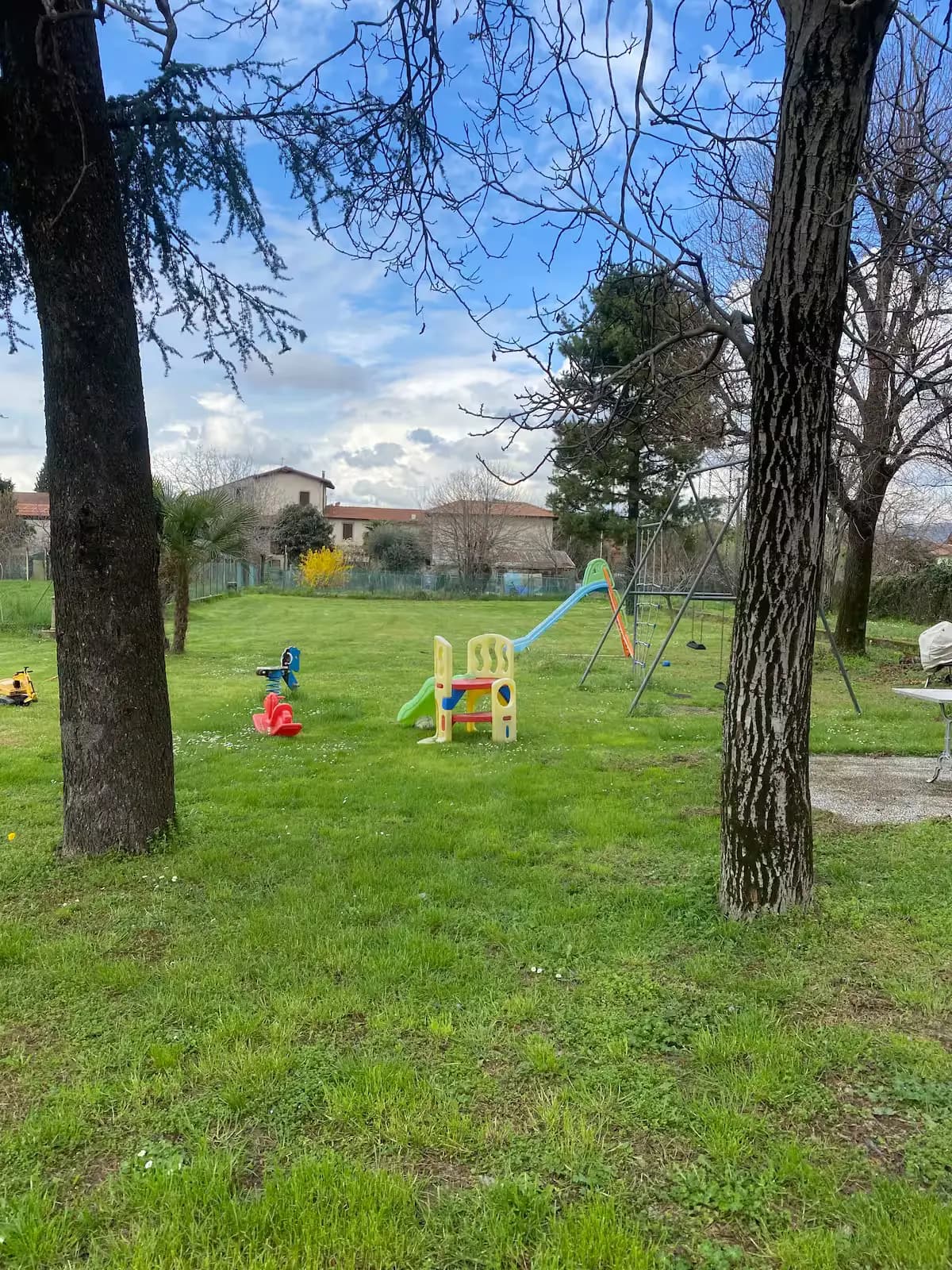 Parco giochi per bambini con attrezzature colorate in primavera